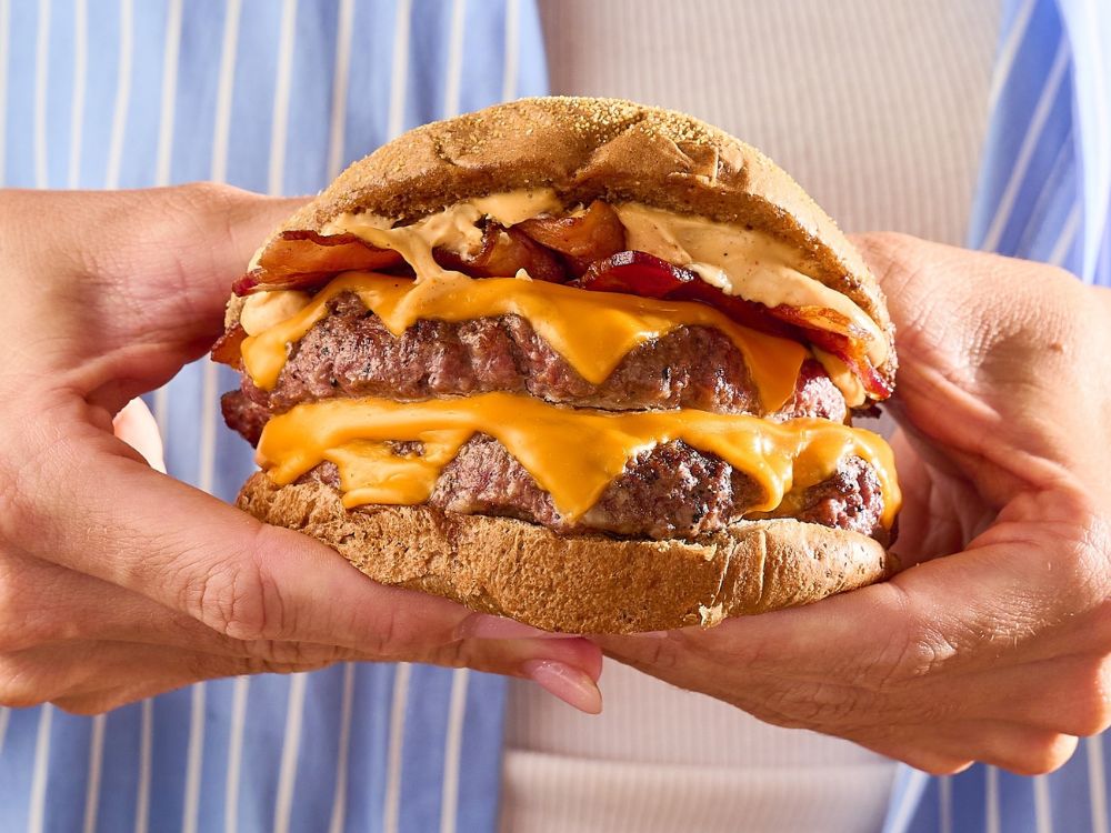 Hambúrguer artesanal com bacon e queijo servido em pão rústico, destaque no cardápio da franquia de hambúrguer artesanal Meatz Burger.