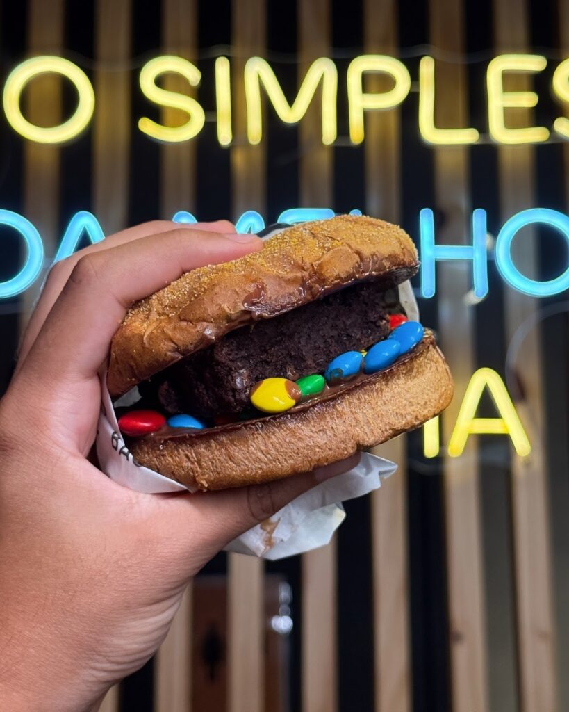 Hambúrguer doce criativo com brownie e confeitos coloridos, mostrando a inovação e originalidade de uma franquia de hambúrguer diferenciada.